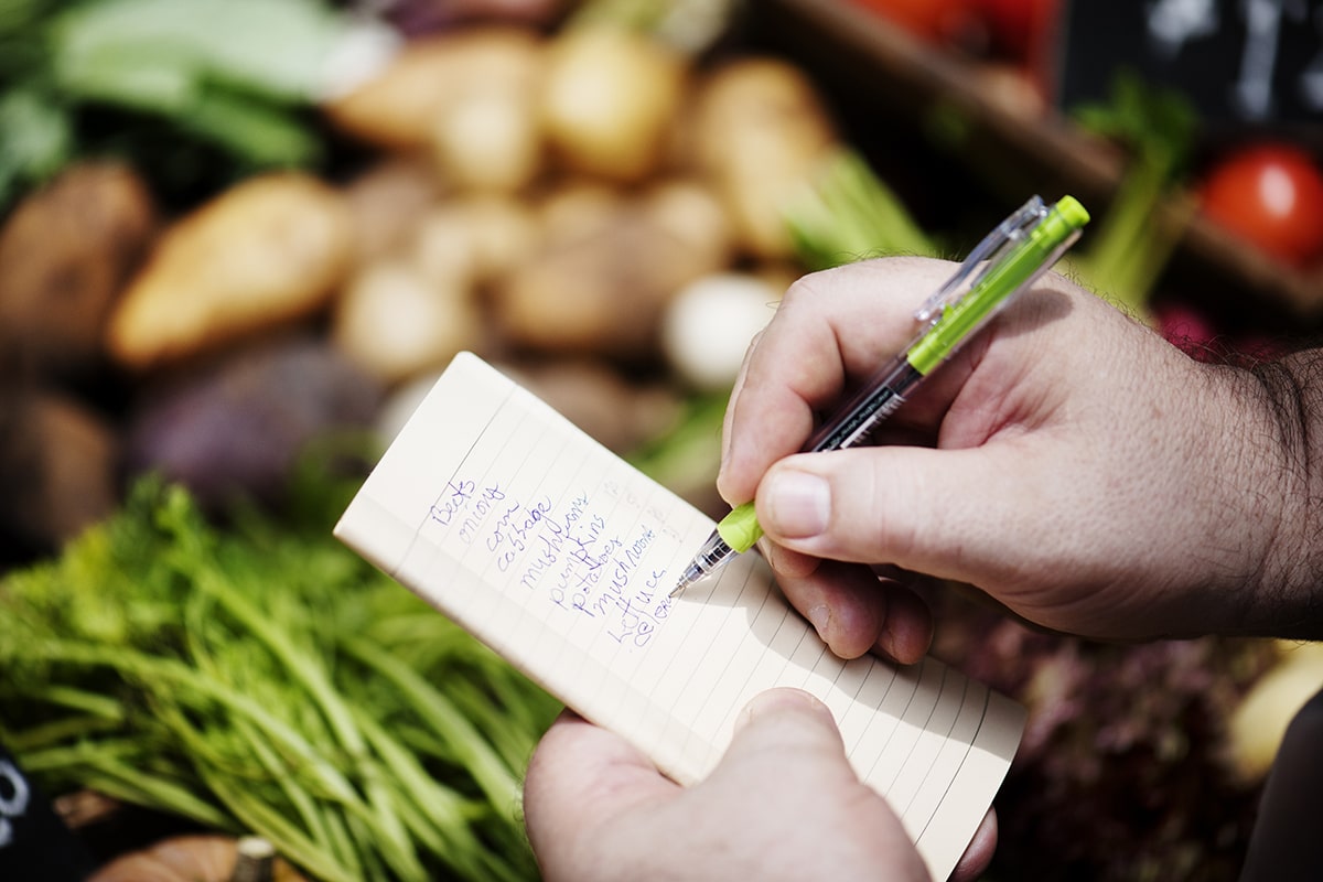 Writing a list of foods in front of vegetables