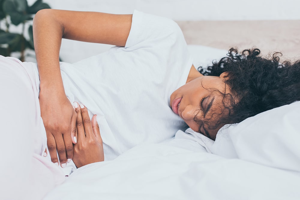 woman laying down with stomach pain