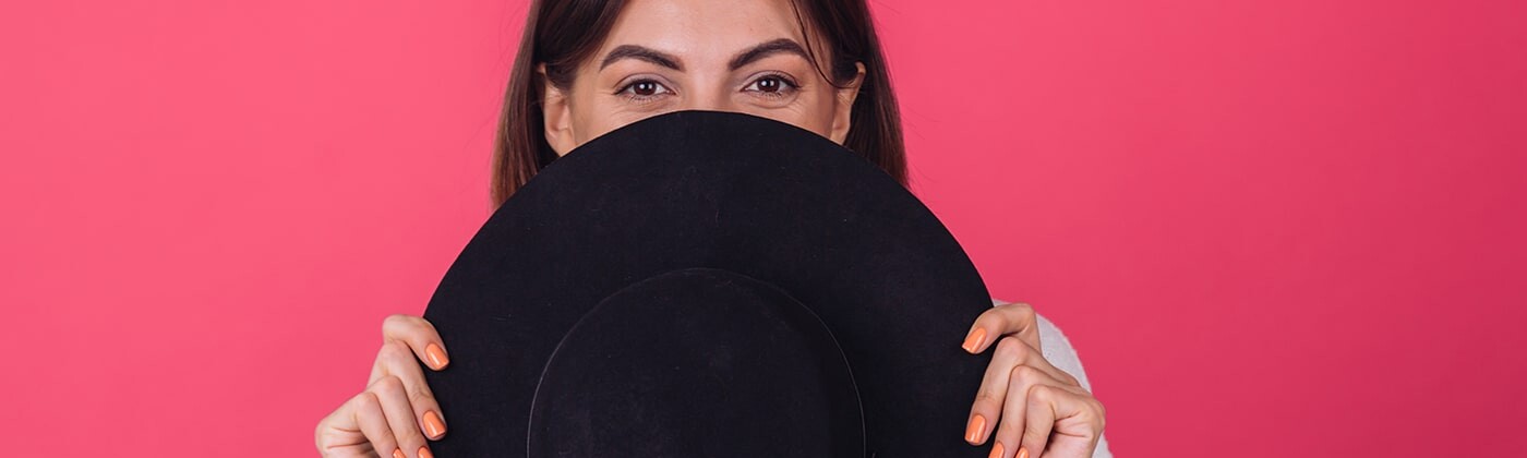 woman hiding behind hat
